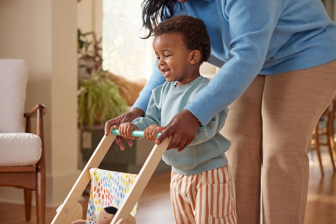 Boy and mom pushing The Buddy Stroller by Lovevery