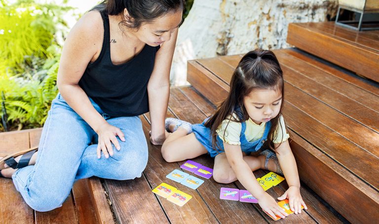 Toddler and woman sitting outside playing the matching game